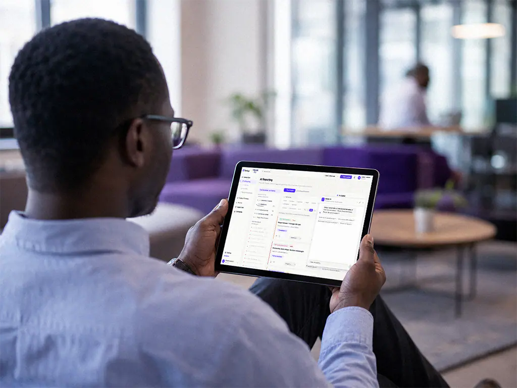 Collaborateur interrogeant un assistant IA sur sa tablette, dans un espace de travail