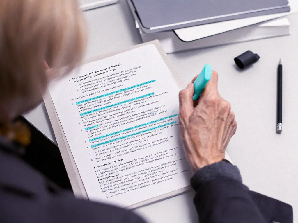Contrat imprimé annoté au surligneur, passages clés mis en évidence