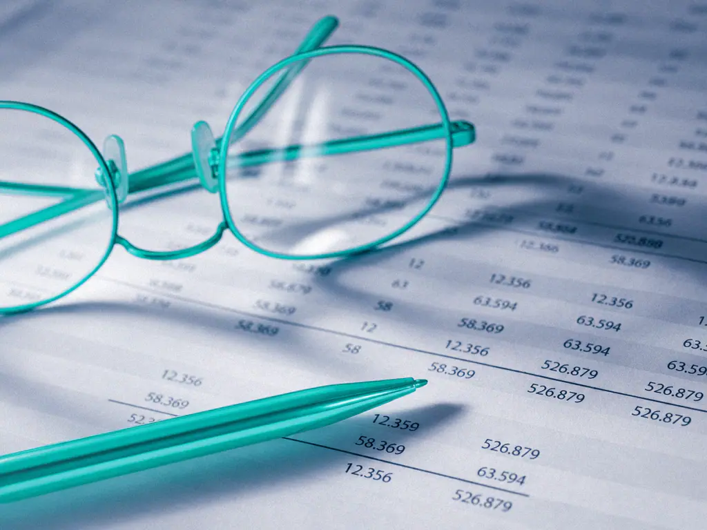 Tableau de chiffres imprimé, lunettes et stylo posés dessus