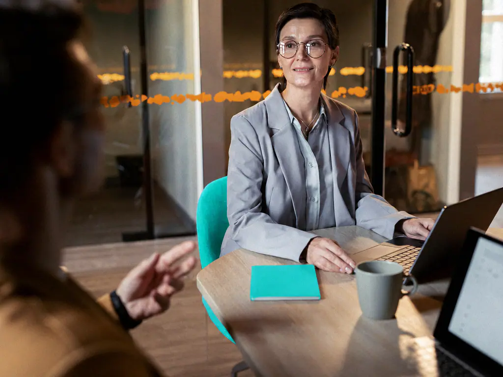 Candidate en entretien de recrutement, échange détendu autour d’une table