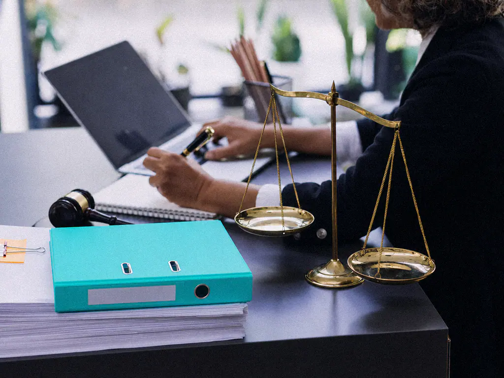 Balance de la justice, marteau de juge, classeur et ordinateur portable sur un bureau