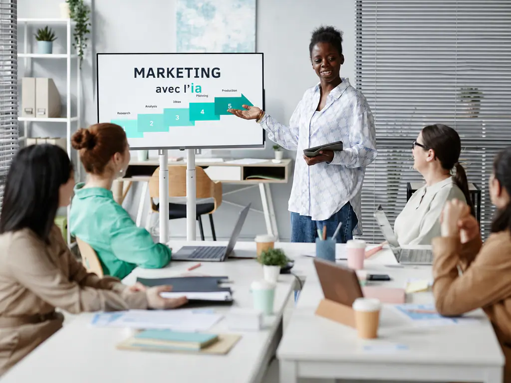 Une formatrice présente « Marketing avec l’IA » à une équipe d’agence
