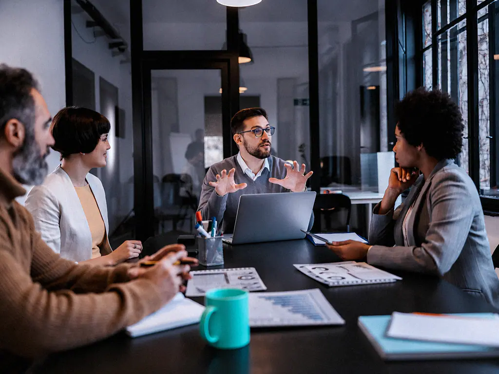 Réunion d’équipe autour d’une table de travail avec un ordinateur portable