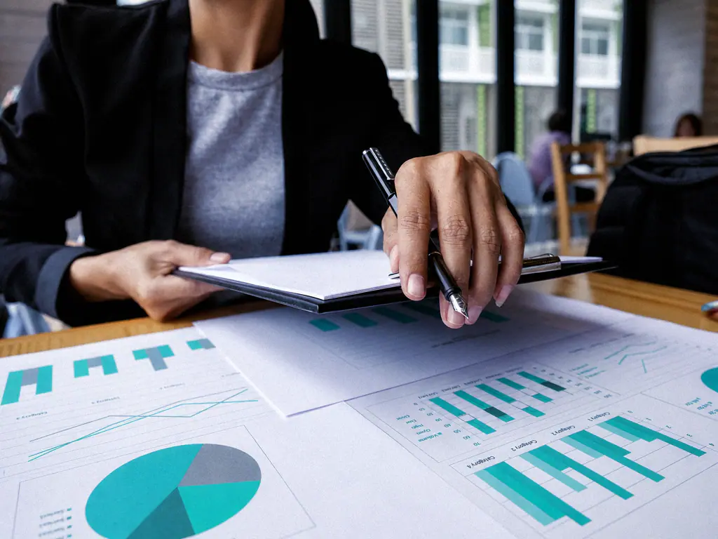 Des mains annotent des graphiques imprimés sur une table de travail