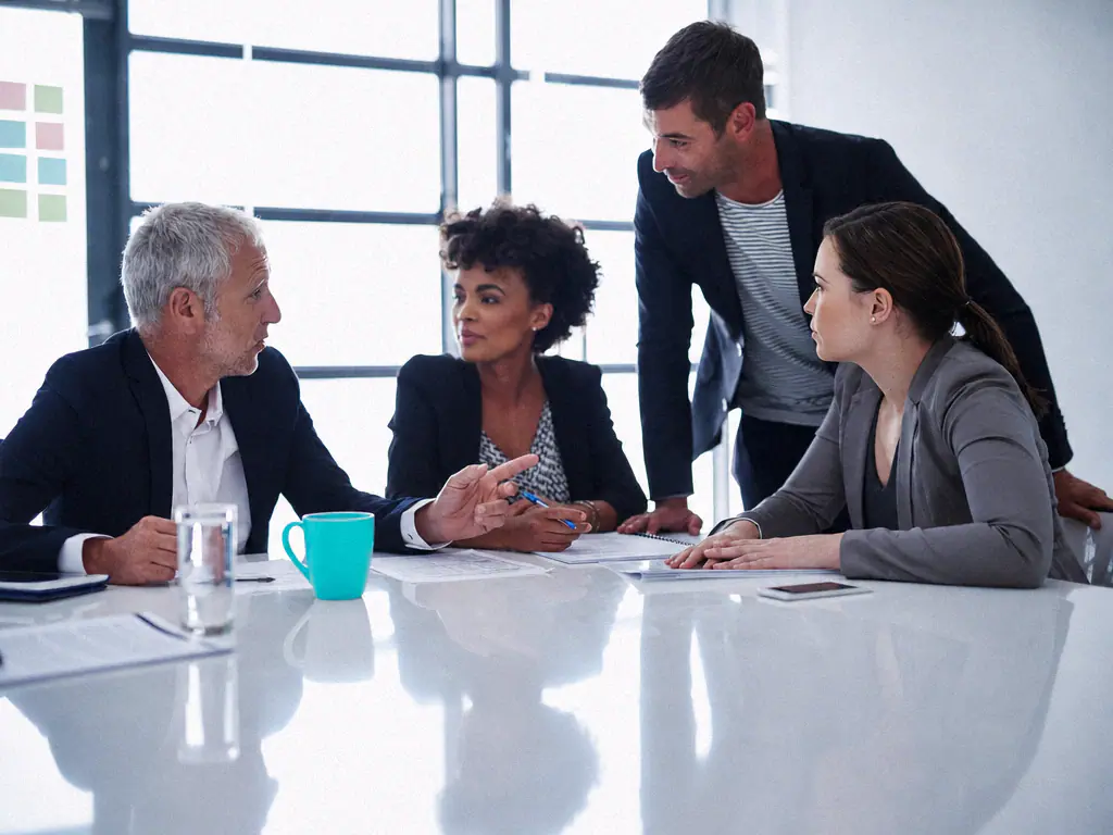 Une équipe de consultants échange autour d’une table de réunion