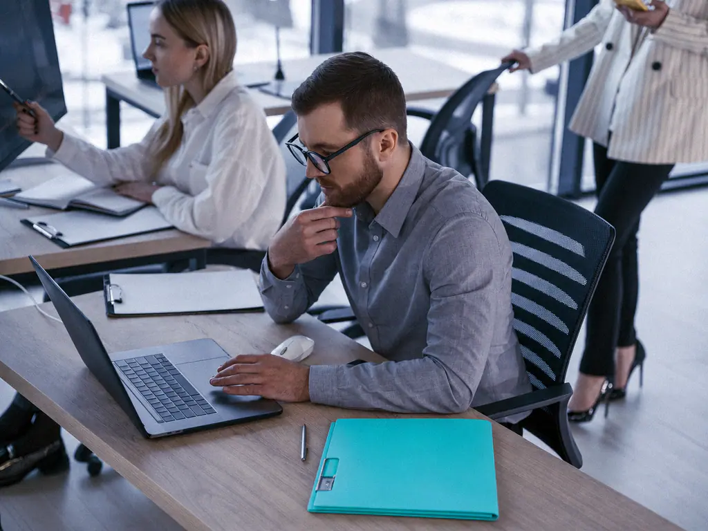 Un consultant travaille sur son ordinateur dans un espace de bureaux ouvert