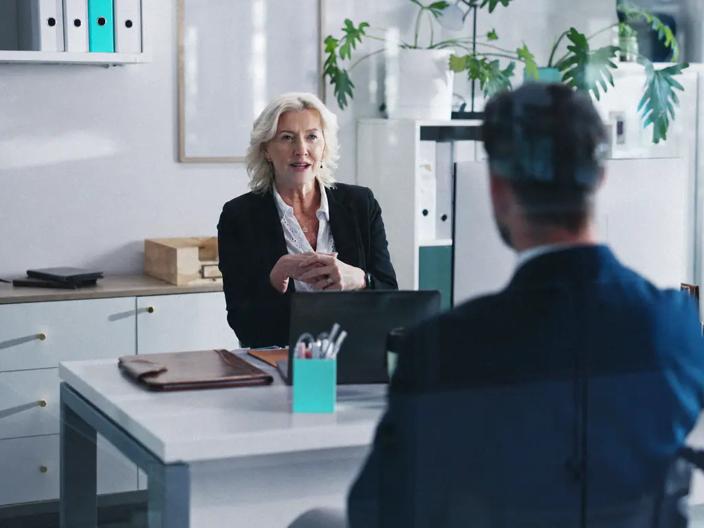 Entretien entre une responsable et un interlocuteur dans un bureau lumineux