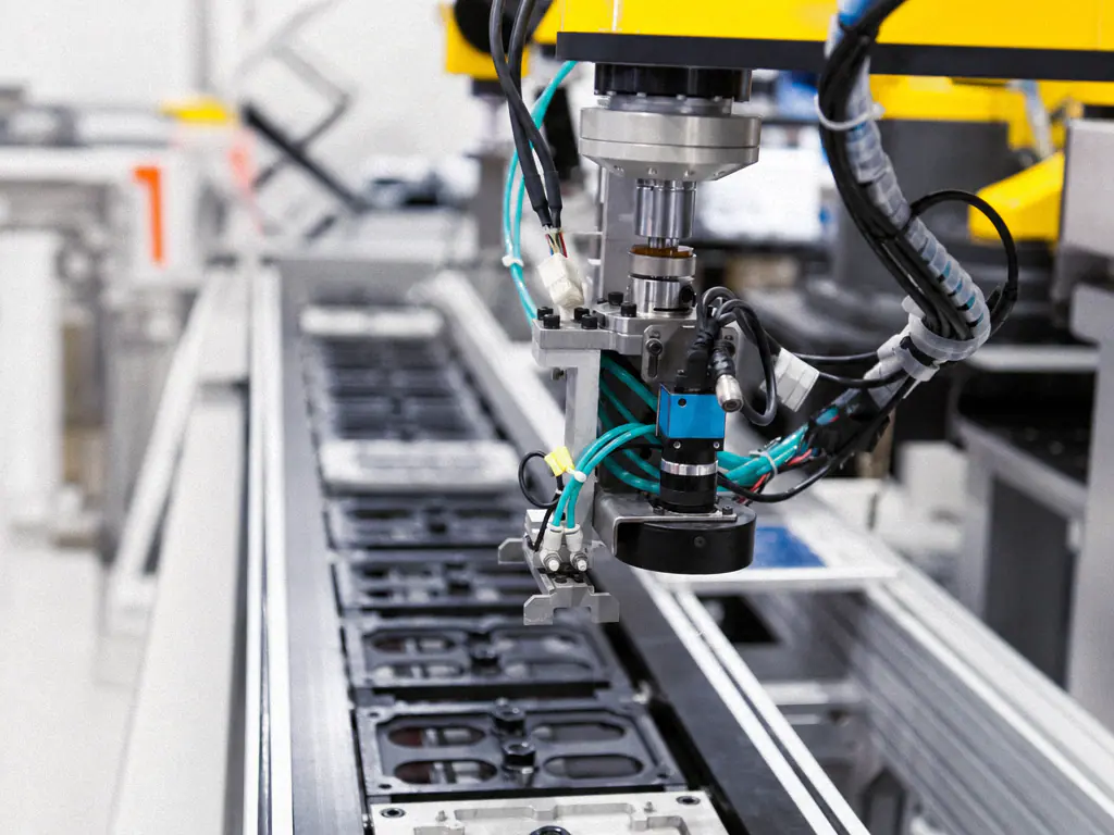 Caméra industrielle d’inspection montée au dessus d’un convoyeur de pièces