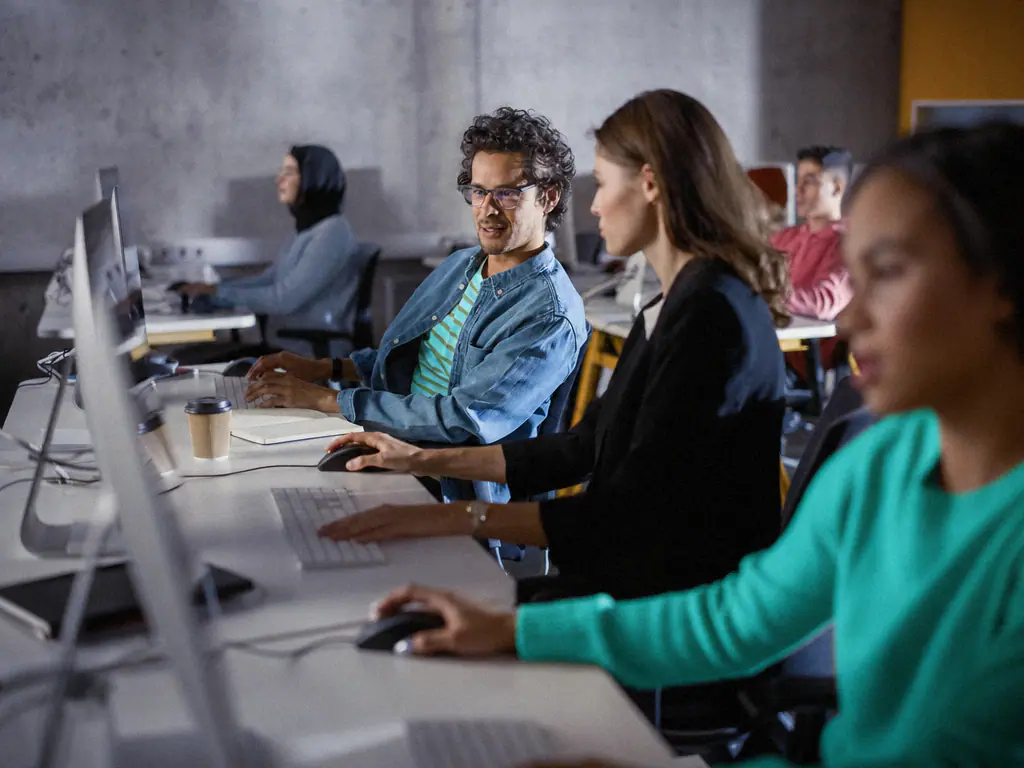 Apprenants travaillant sur des postes informatiques dans une salle de cours