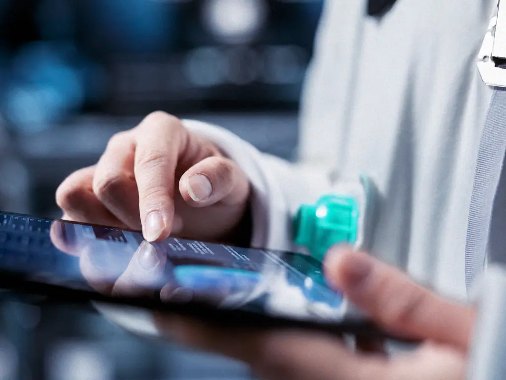 Gros plan sur une main qui consulte des résultats sur une tablette