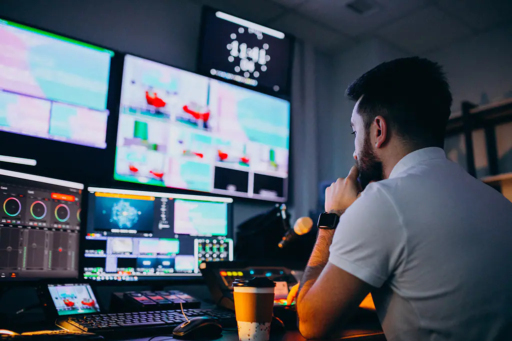 Un technicien surveille les écrans d’une régie vidéo pendant une diffusion