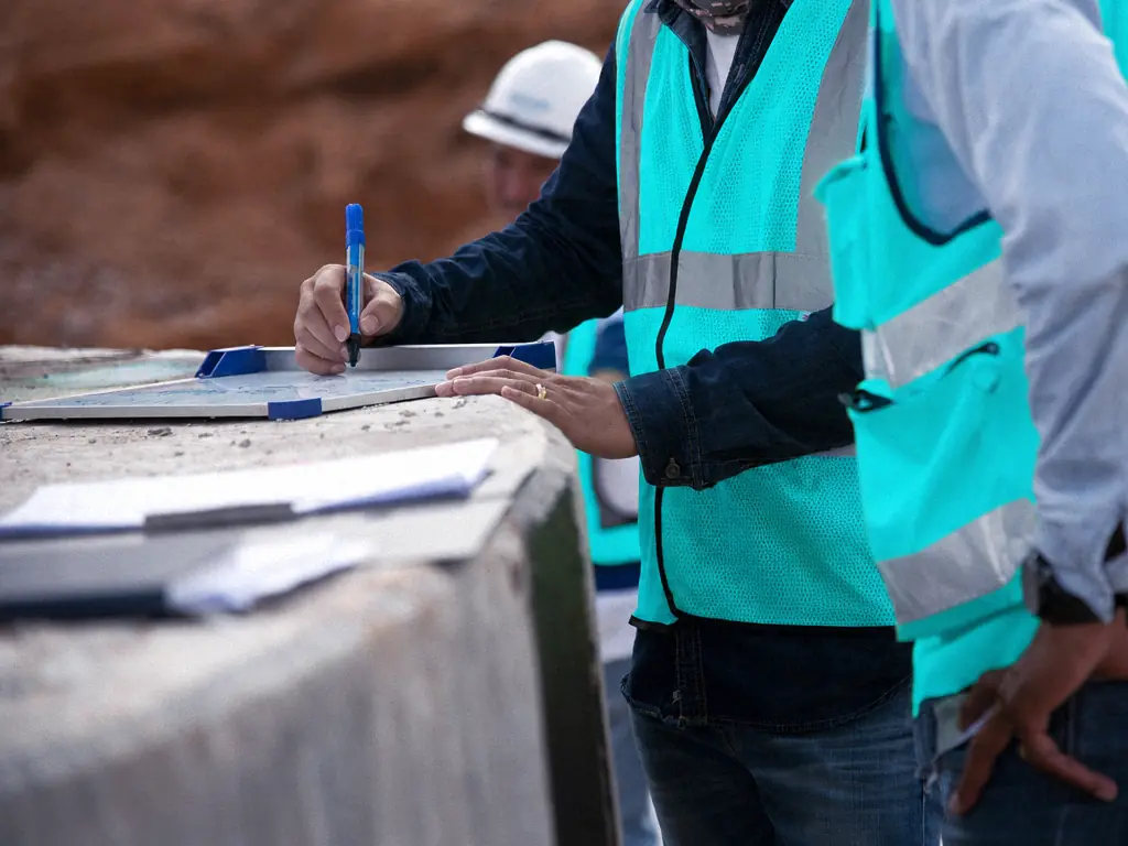 Chef de chantier annotant un document sur le terrain