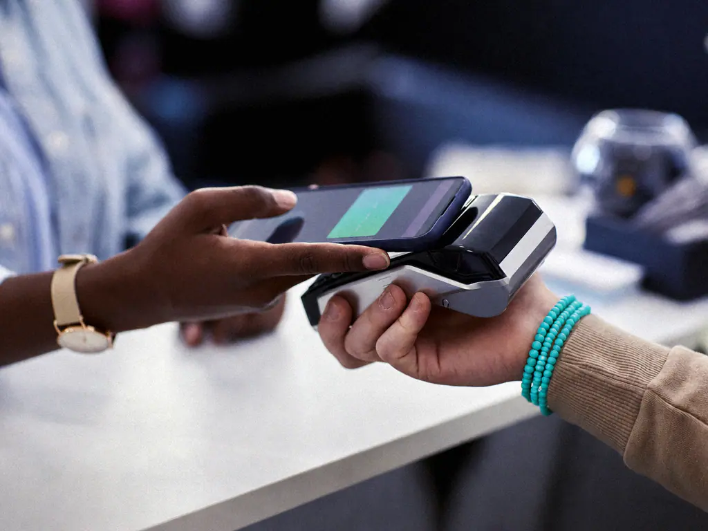 Paiement sans contact par téléphone sur un terminal tenu par un vendeur