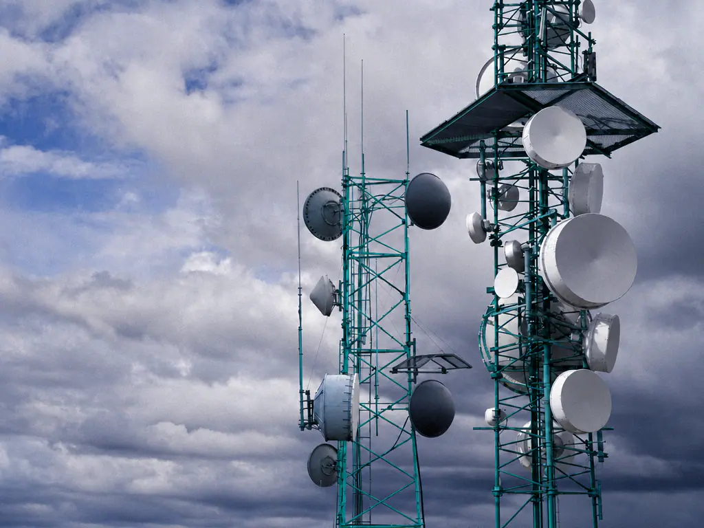 Deux pylônes d’antennes de télécommunications sous un ciel nuageux