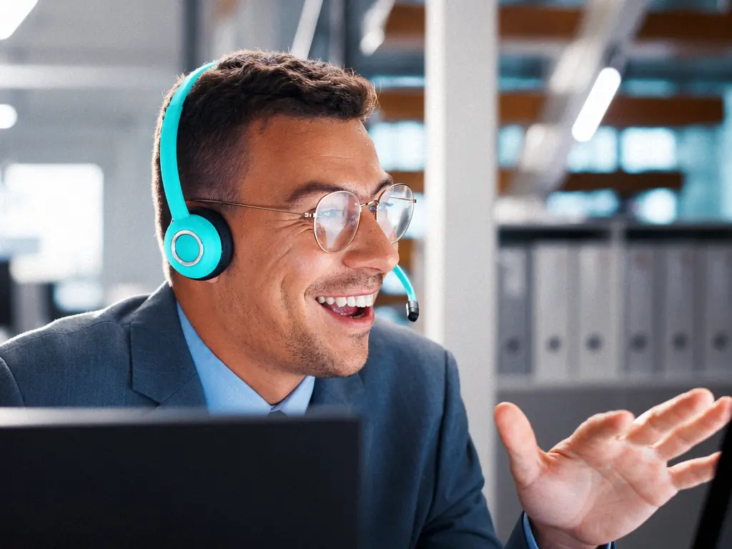 Chargé de clientèle au casque, en conversation devant son écran