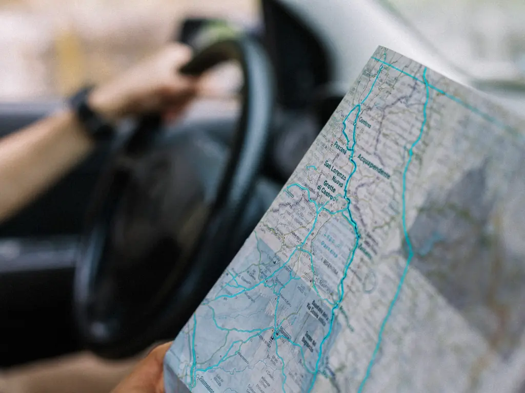 Carte routière annotée tenue au volant d’un véhicule de livraison