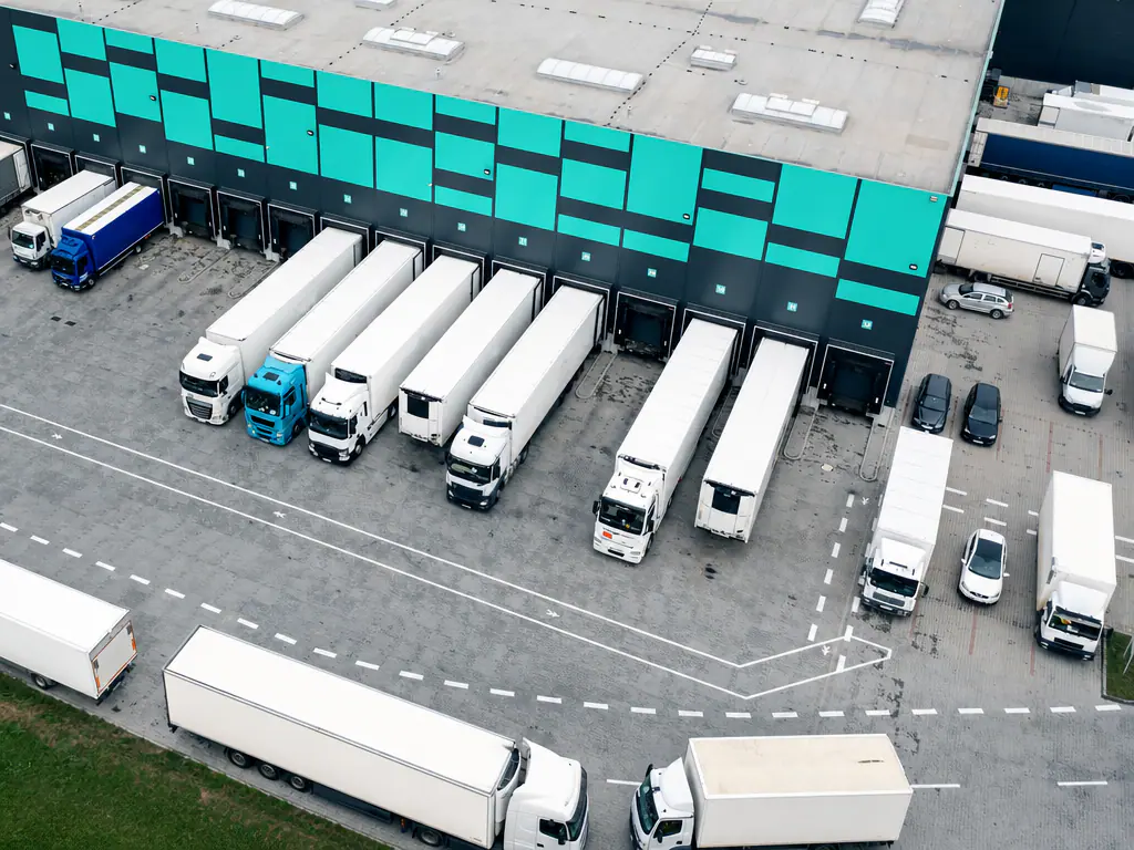 Vue aérienne de camions et de semi-remorques stationnés à quai devant une plateforme logistique